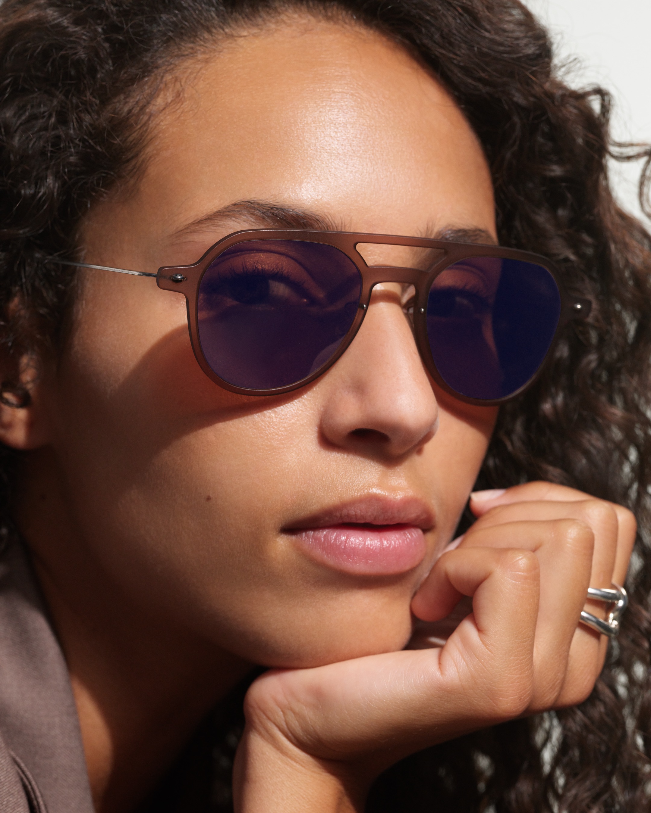 Close-up of a woman wearing screwless Lindberg glasses, the thin titanium temple visible by the ear